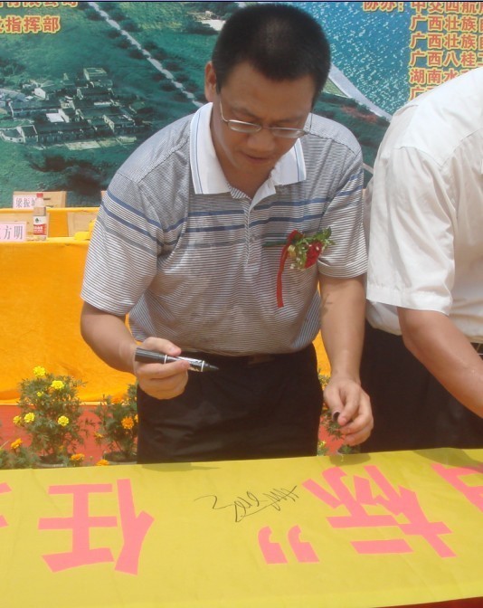 廣西新港灣公司副總經(jīng)理姚方明在“奮戰(zhàn)100天，如期實(shí)現(xiàn)魚(yú)梁工程截流、通航、發(fā)電‘三大目標(biāo)’”橫幅上簽字